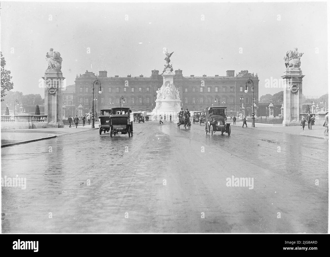 Buckingham Palace, The Mall, St James, City of Westminster, Greater London Authority, 1911. Vue depuis le Mall of Buckingham Palace, montrant la fontaine du Queen Victoria Memorial et les jetées, avec des voitures et une calèche au premier plan. Banque D'Images