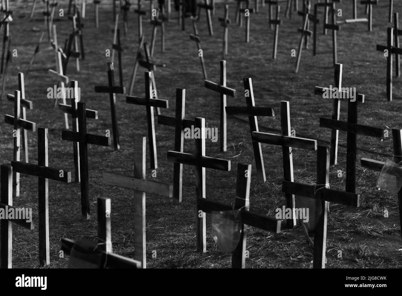 une photo en échelle de gris d'un cimetière avec des croix fixées au sol en l'honneur de ceux tués par le covid-19 Banque D'Images