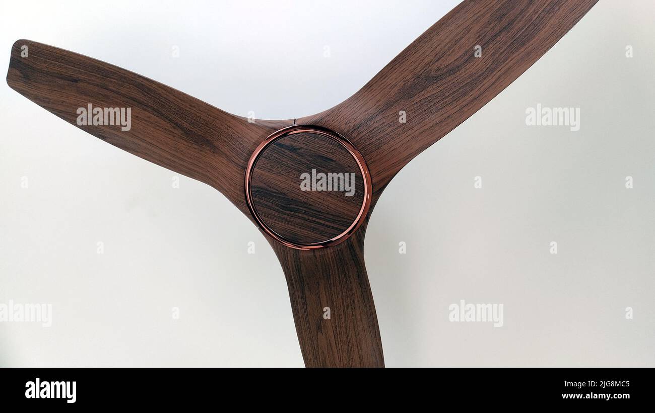 Photo à faible angle d'un ventilateur de plafond avec une touche de bois isolée sur fond blanc Banque D'Images