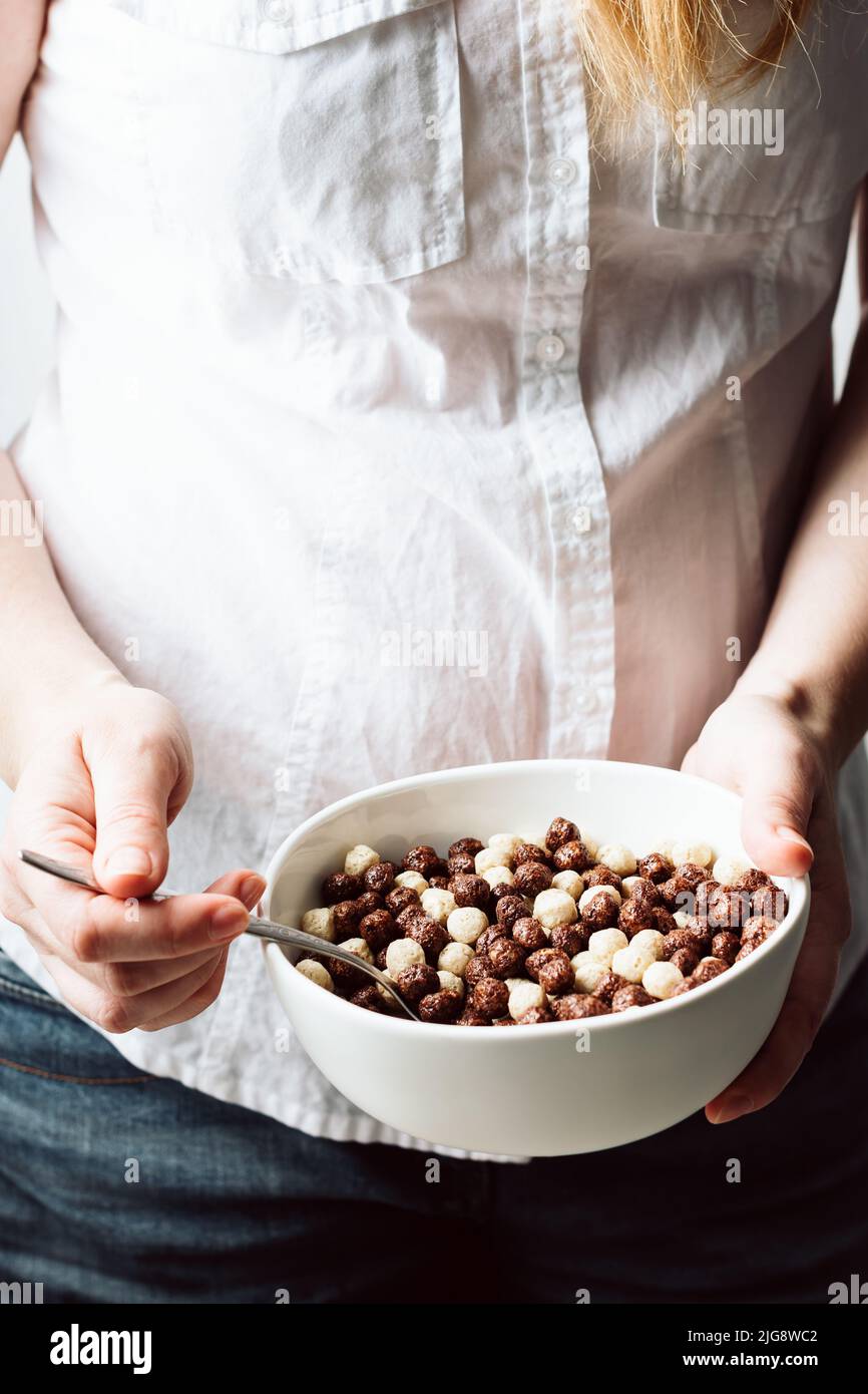 Les mains des femmes tiennent un bol de céréales pour le petit déjeuner. Banque D'Images