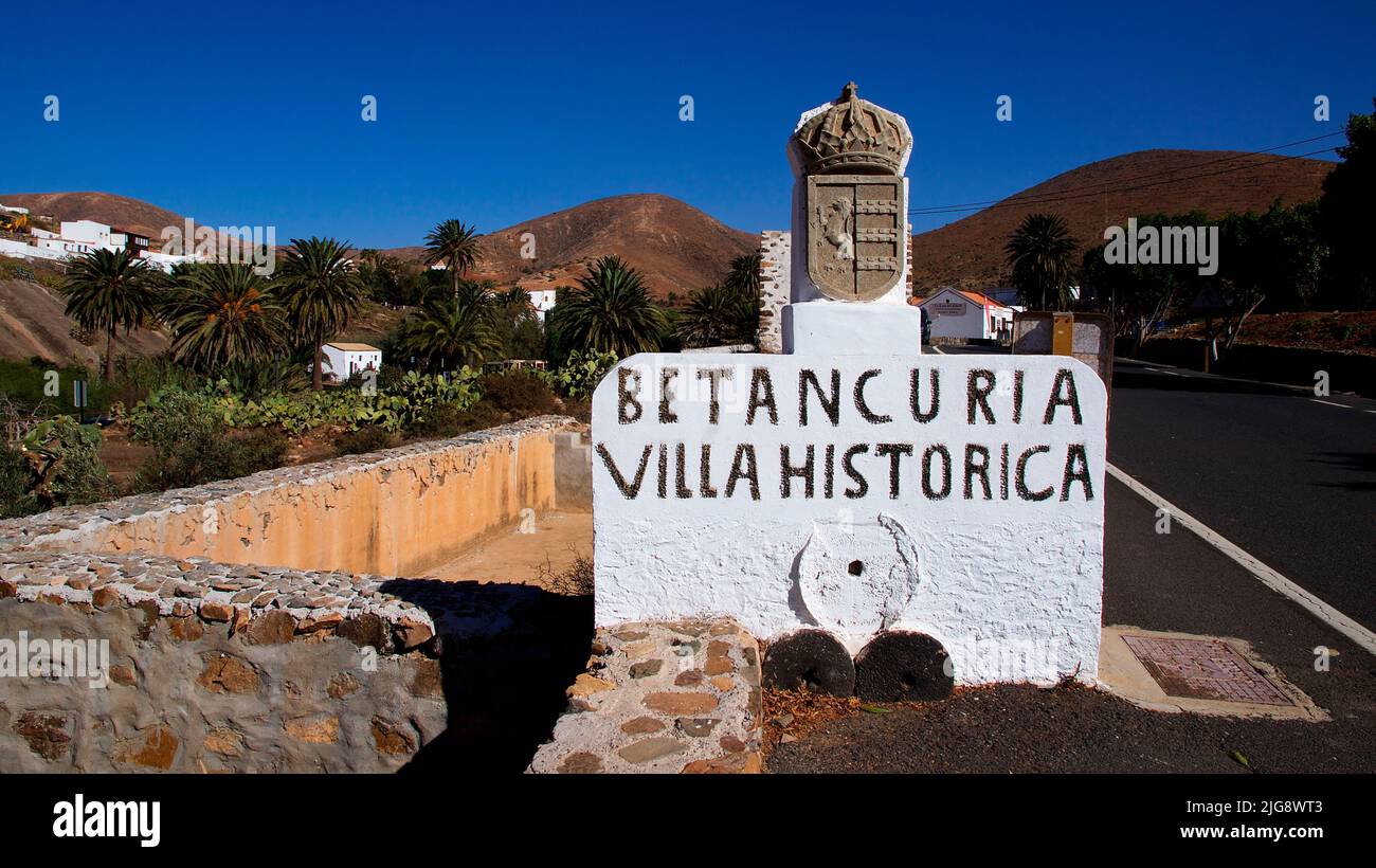 Espagne, Iles Canaries, Fuerteventura, Betancuria, Vieille capitale, Vieille ville, panneau d'entrée de la ville blanche en pierre, Villa Historica, Asphalt Road, Blue Cloudless Sky Banque D'Images