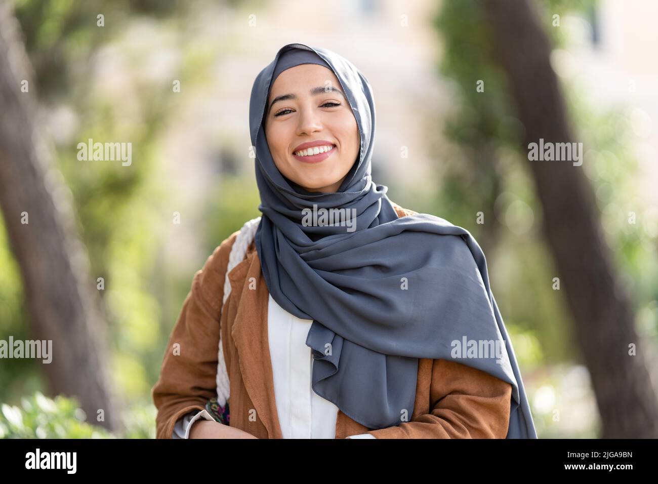Femme musulmane dans hijab souriant à la caméra Banque D'Images