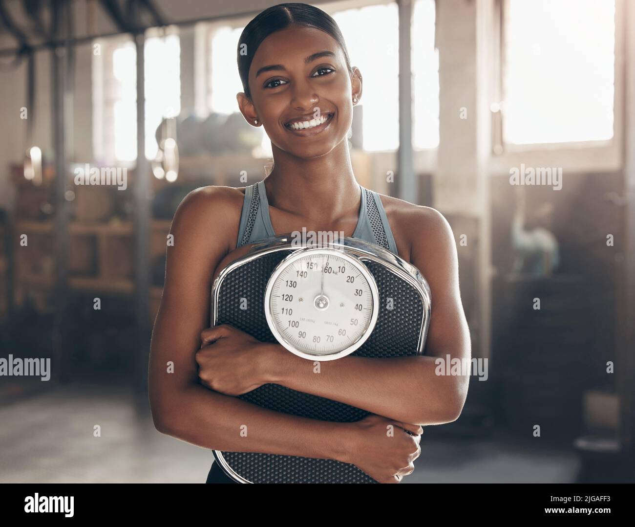 J'ai mis dans l'effort et les résultats sont étonnants. Portrait d'une jeune femme sportive portant une balance dans une salle de sport. Banque D'Images