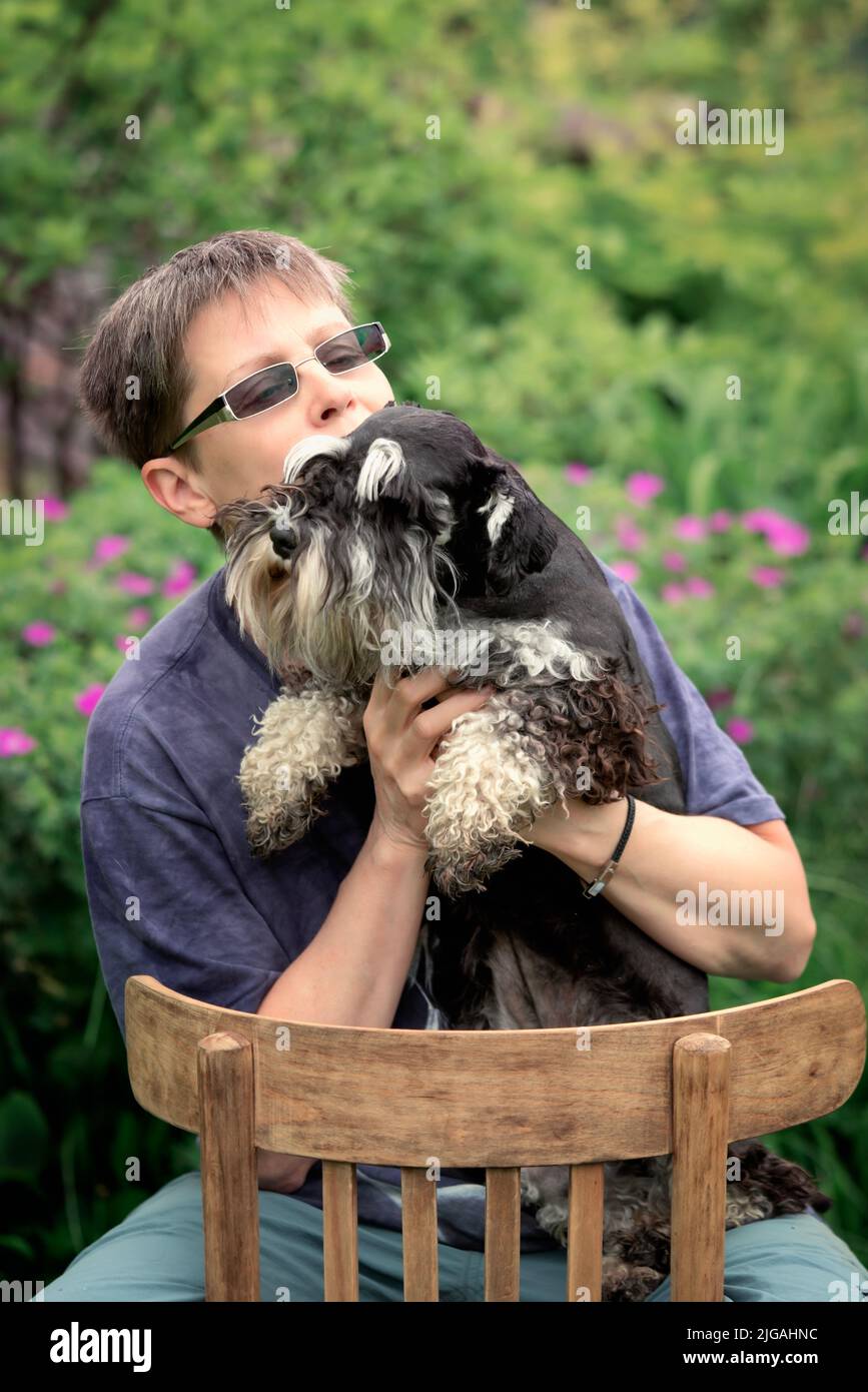 Femme avec son chien schnauzer miniature assis à l'extérieur Banque D'Images