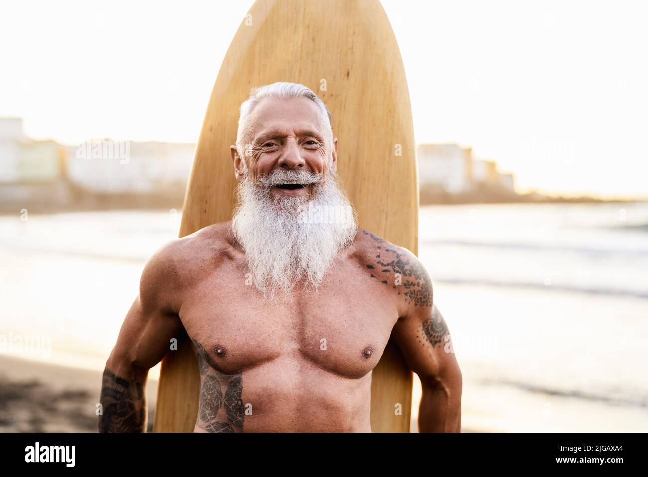 Homme senior ayant le plaisir de surfer sur la plage tropicale - personnes âgées saines mode de vie et sport extrême concept Banque D'Images