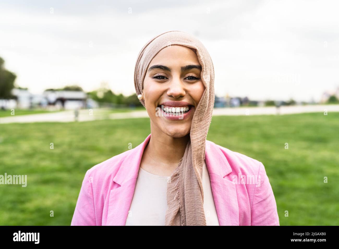 Bonne femme musulmane s'amusant en posant devant l'appareil photo dans un parc Banque D'Images