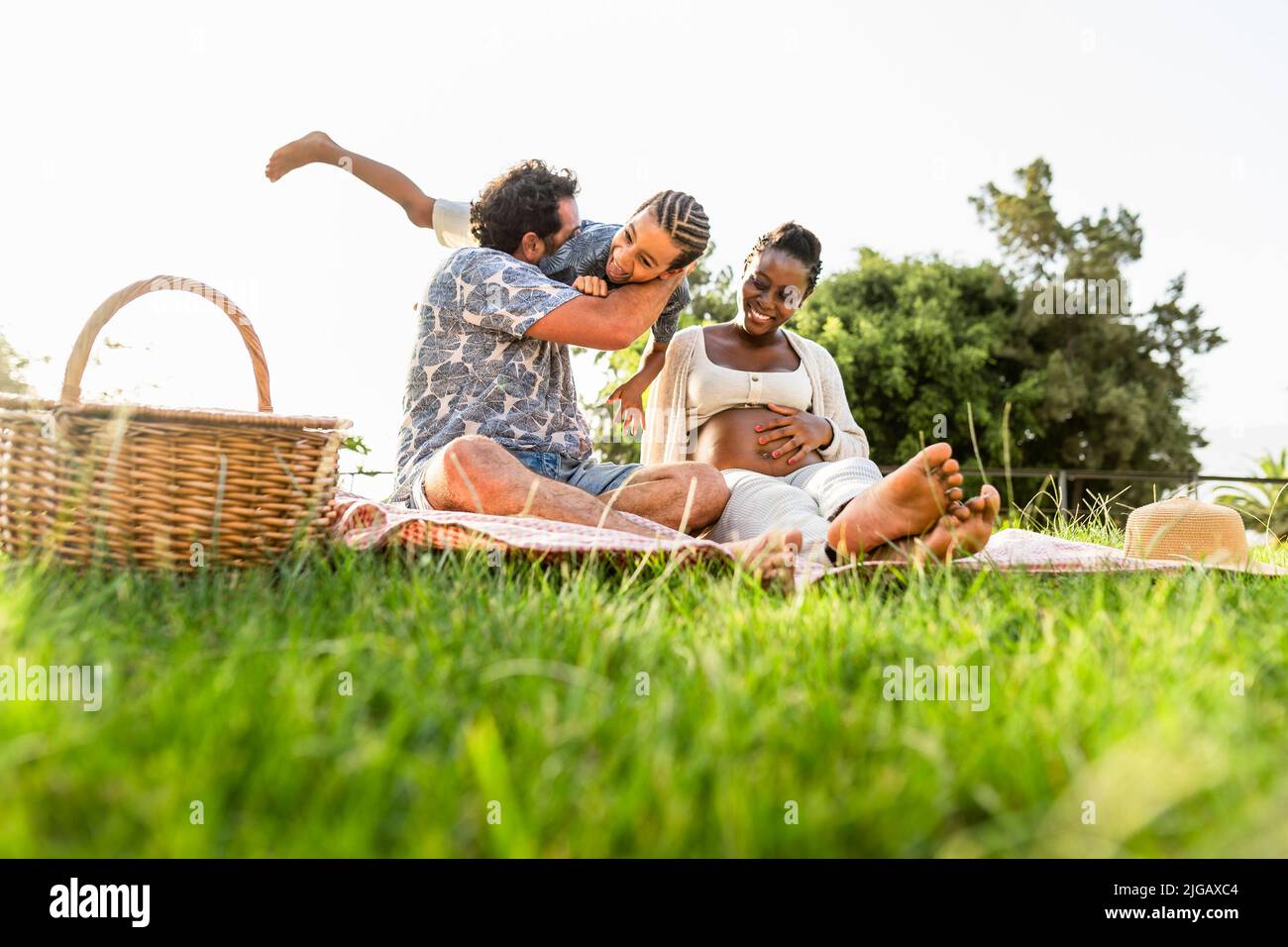 Bonne famille multiraciale s'amusant ensemble tout en faisant un pique-nique dans le parc Banque D'Images