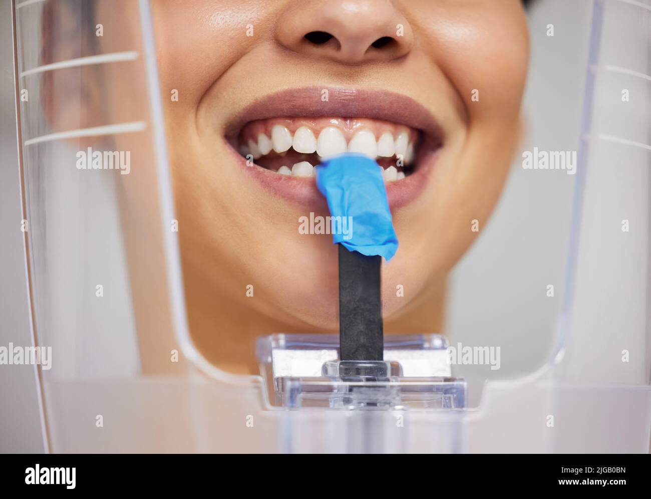 Mon dentiste m'a dit mordre. Une jeune femme utilisant un appareil à rayons X dans un cabinet de dentistes. Banque D'Images