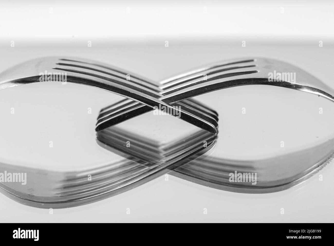 Image de deux fourchettes entrelacées comme une métaphore pour deux mains se tenant l'une l'autre Banque D'Images