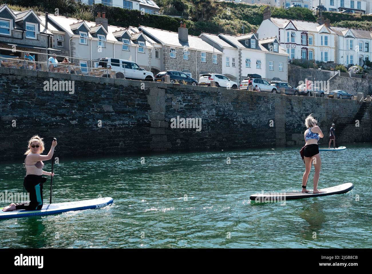 Paddleboard dans le port de Porthleven, Cornouailles Banque D'Images