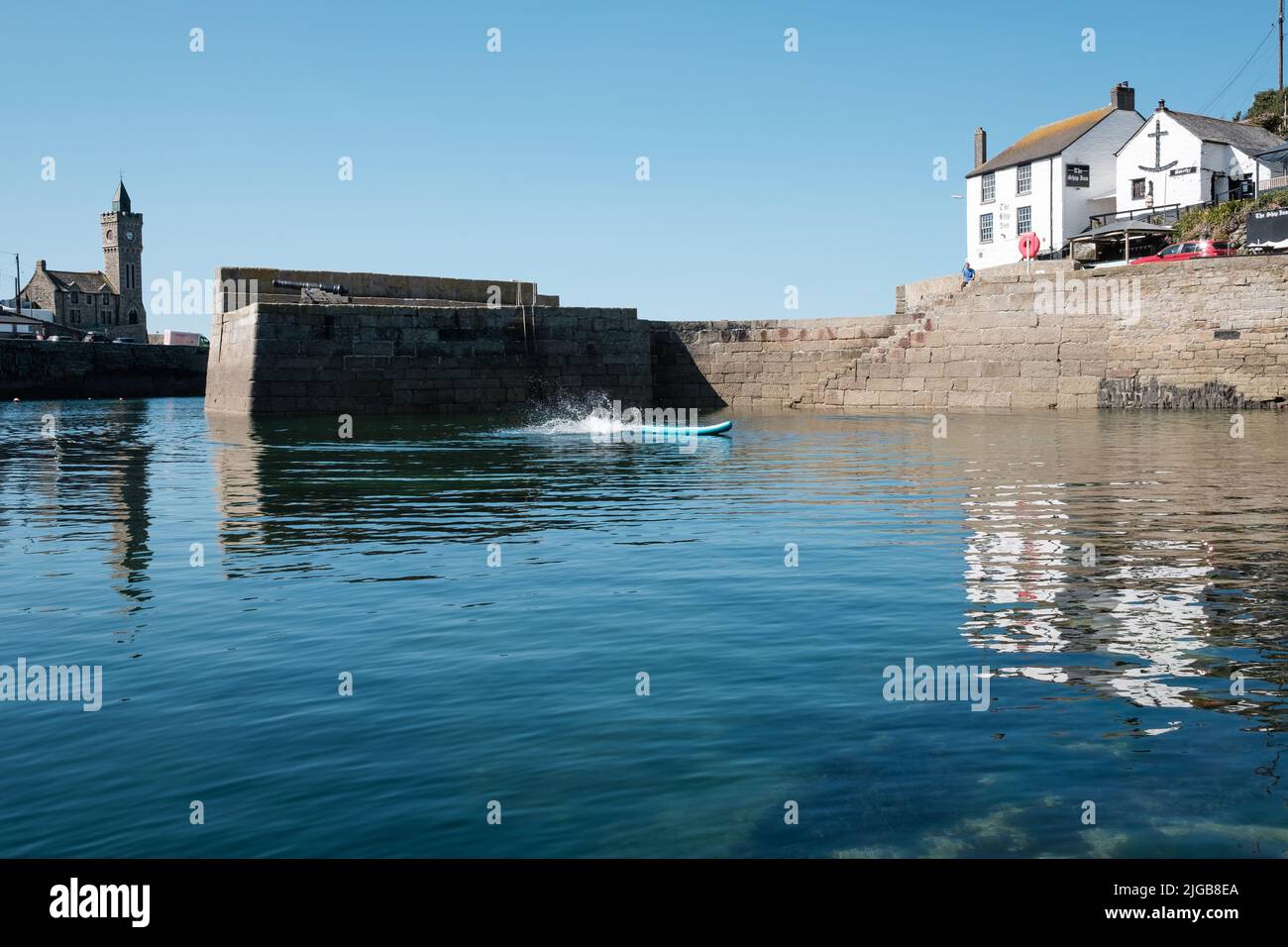 Paddleboard dans le port de Porthleven, Cornouailles Banque D'Images