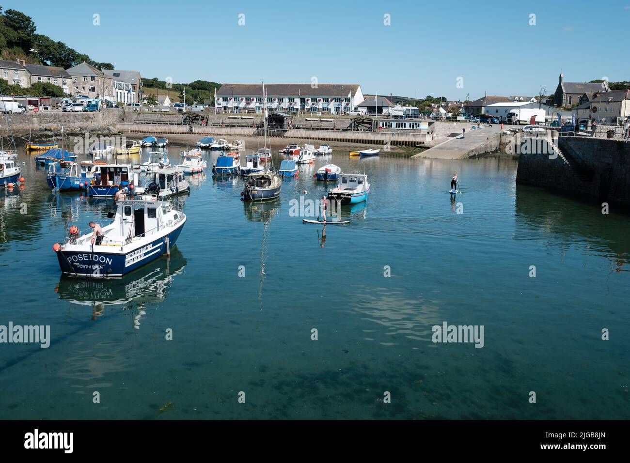 Paddleboard dans le port de Porthleven, Cornouailles Banque D'Images