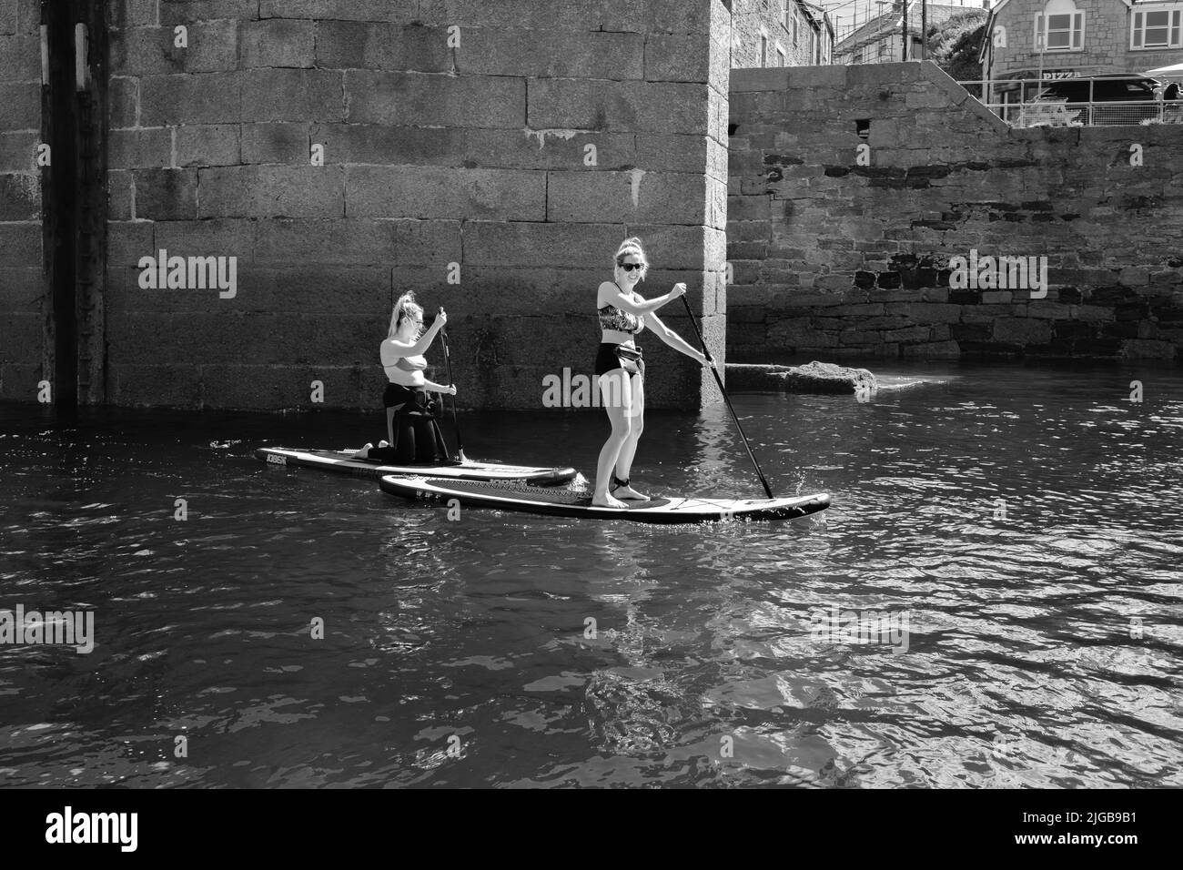 Paddleboard dans le port de Porthleven, Cornouailles Banque D'Images