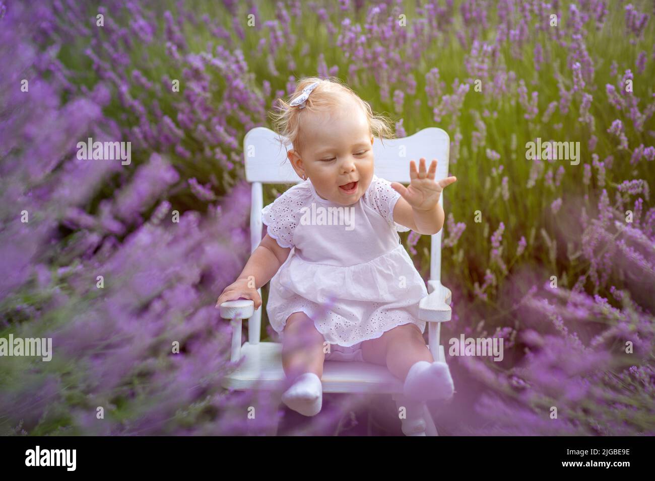 Bonne petite fille assise à la prairie de lavande. Banque D'Images