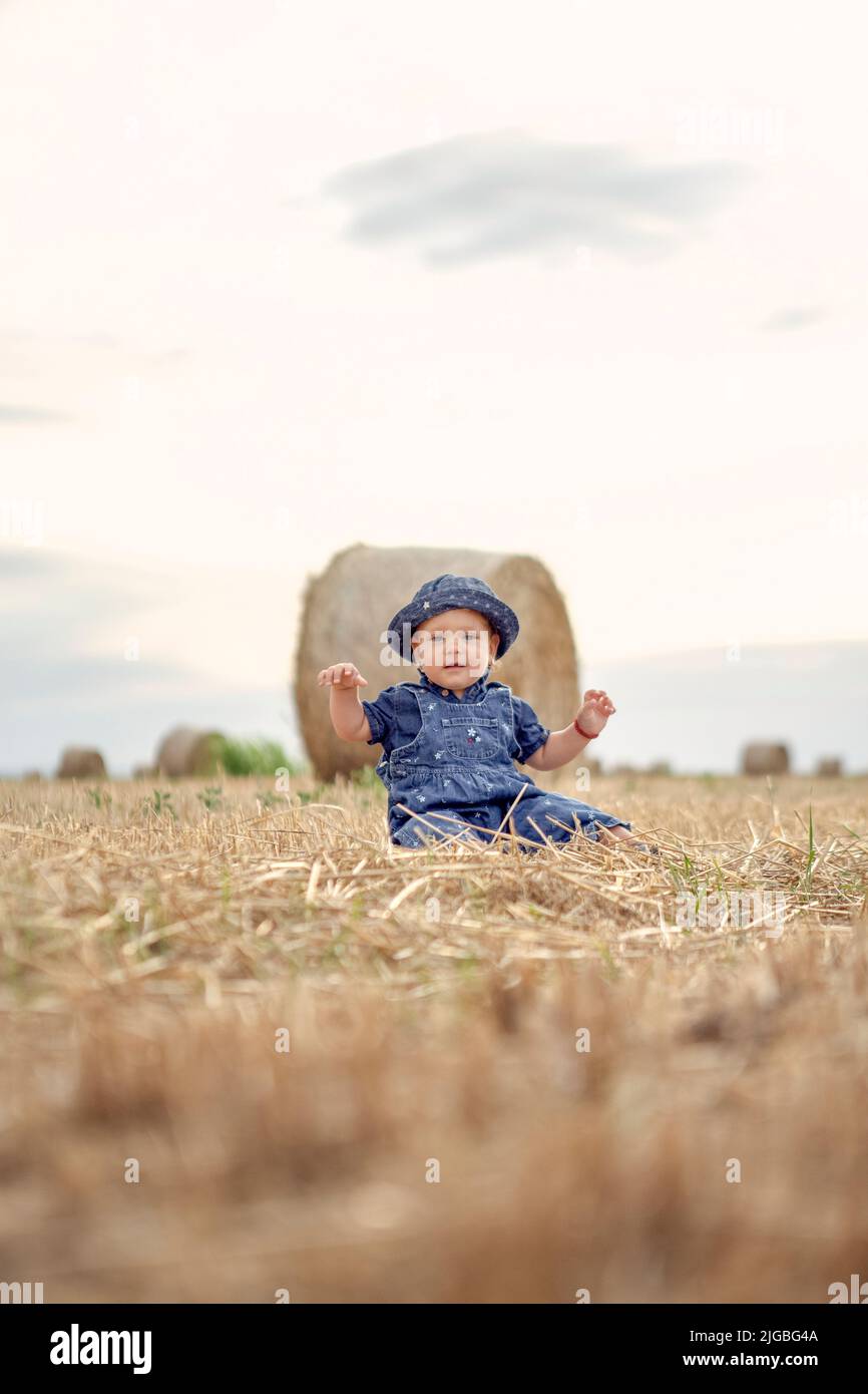 enfant dans un champ de blé. jolie fille sur un champ de blé d'or au coucher du soleil. Banque D'Images