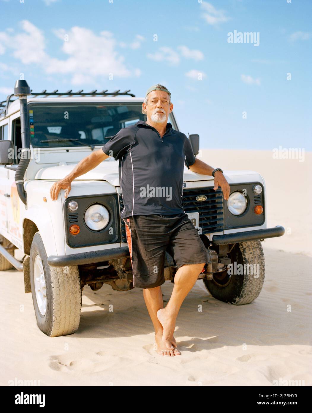 Un guide brésilien se penche contre son Land Rover près de Jericoacoara, Ceará, Brésil, Amérique du Sud. Banque D'Images