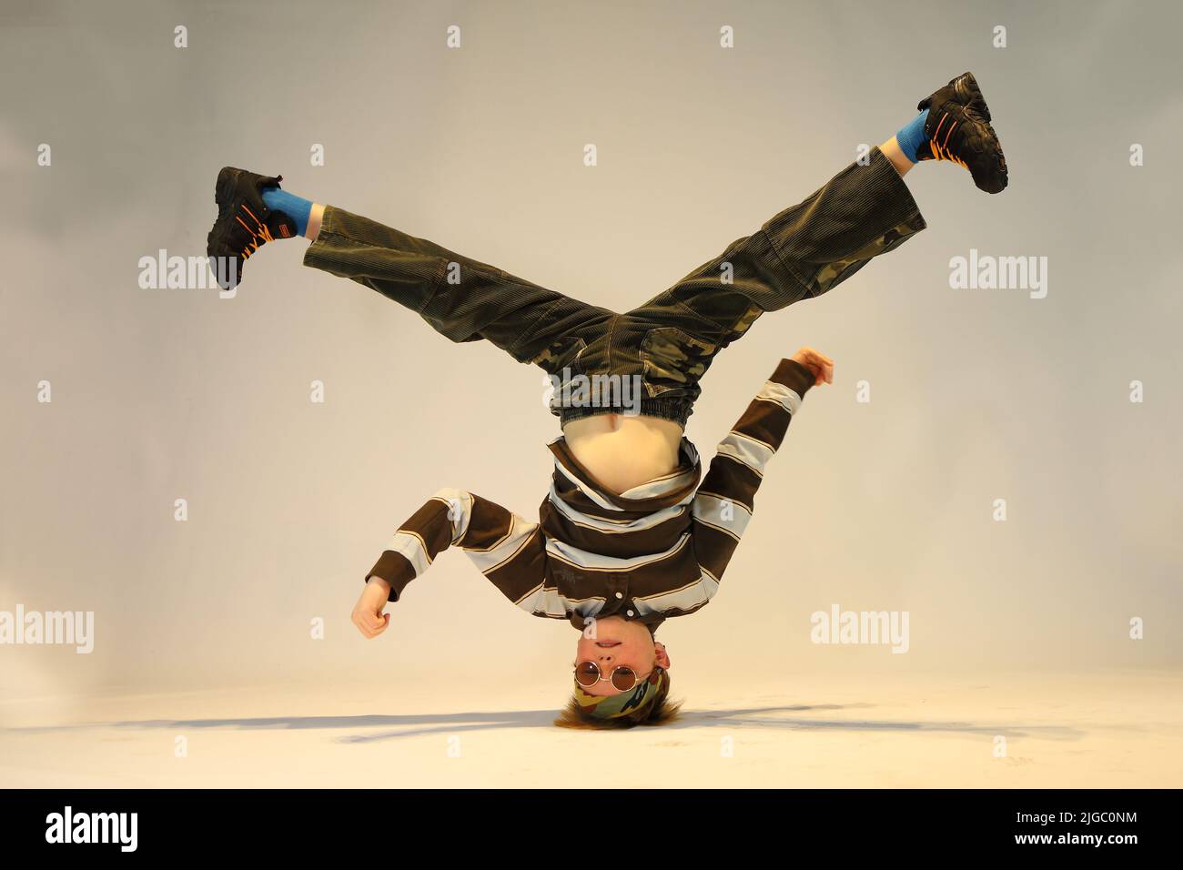 garçon en position de breakdance, position de danse difficile, debout d'une main, debout sur la tête Banque D'Images