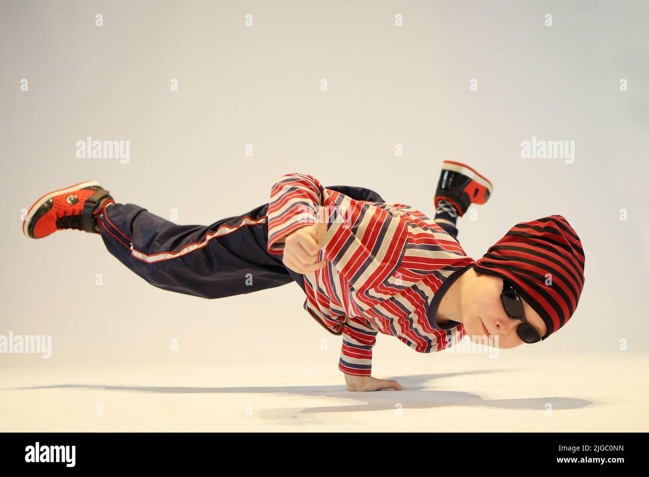 garçon en position de breakdance, position de danse difficile, debout d'une main, debout sur la tête Banque D'Images