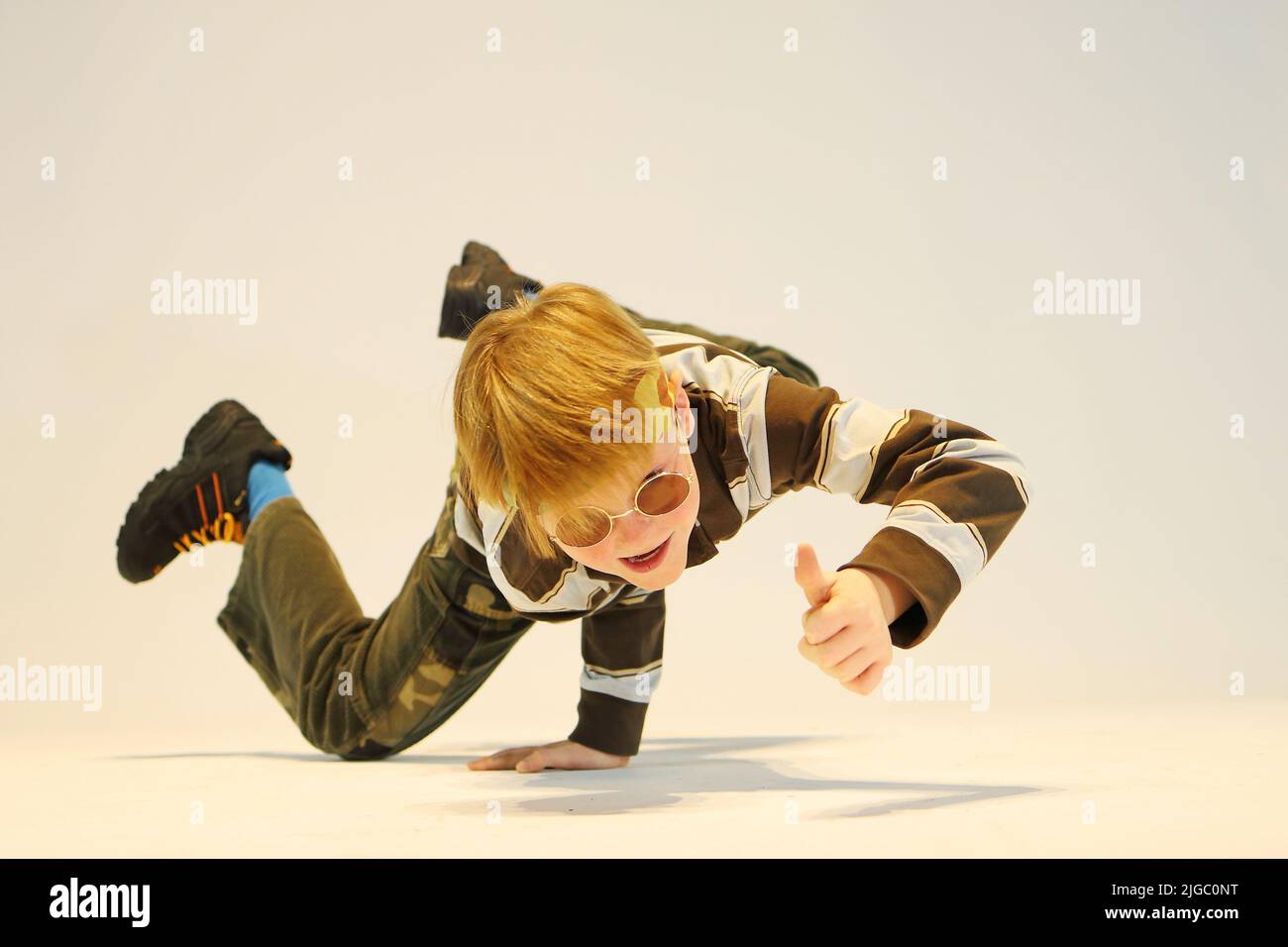 garçon en position de breakdance, position de danse difficile, debout d'une main, debout sur la tête Banque D'Images