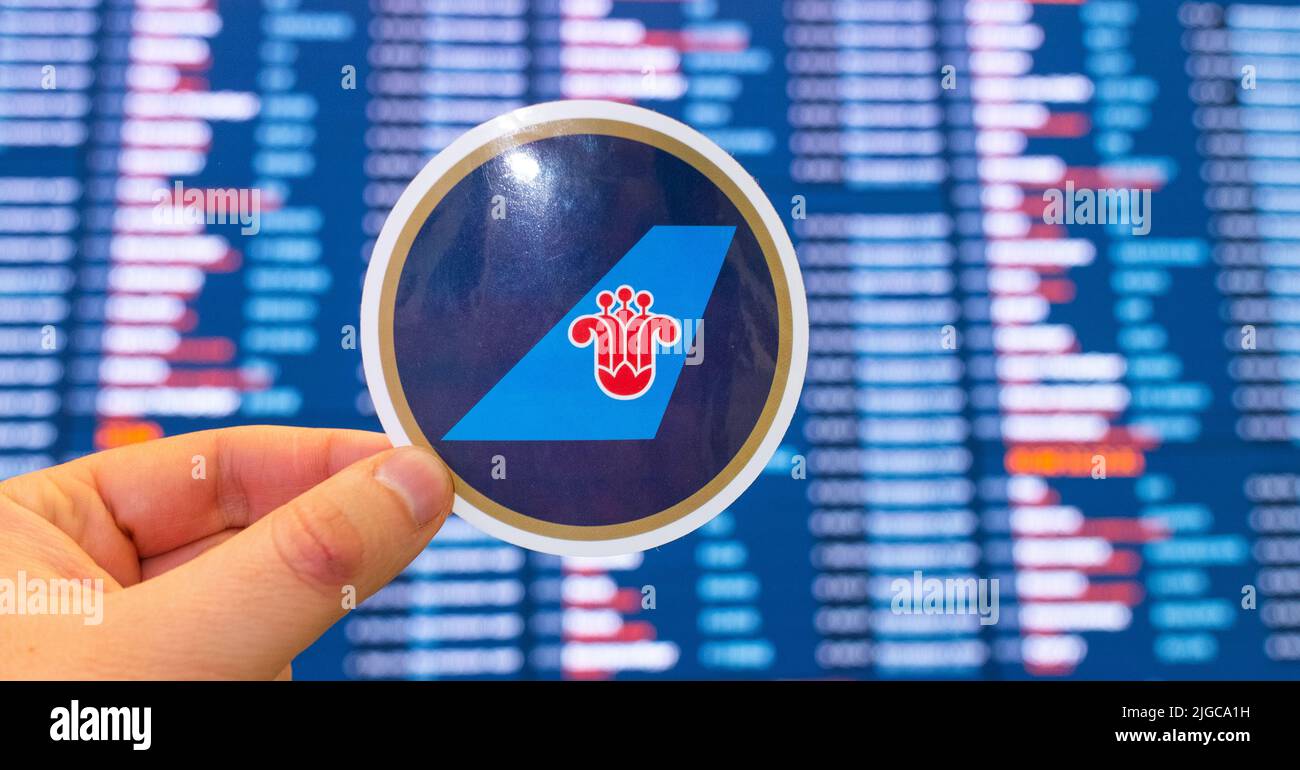 11 décembre 2021, Guangzhou, Chine. L'emblème de China Southern Airlines sur fond de carte électronique avec horaires de vol au Banque D'Images