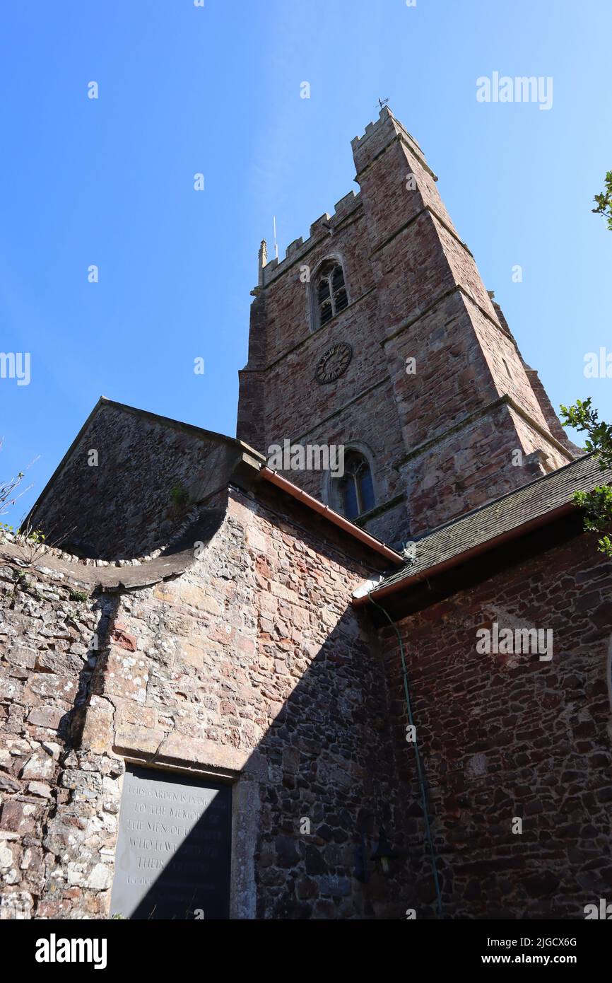 En regardant vers le haut la tour de l'église prieuré de St George à Dunster, Somerset, Angleterre sur un beau ciel sans nuages Banque D'Images