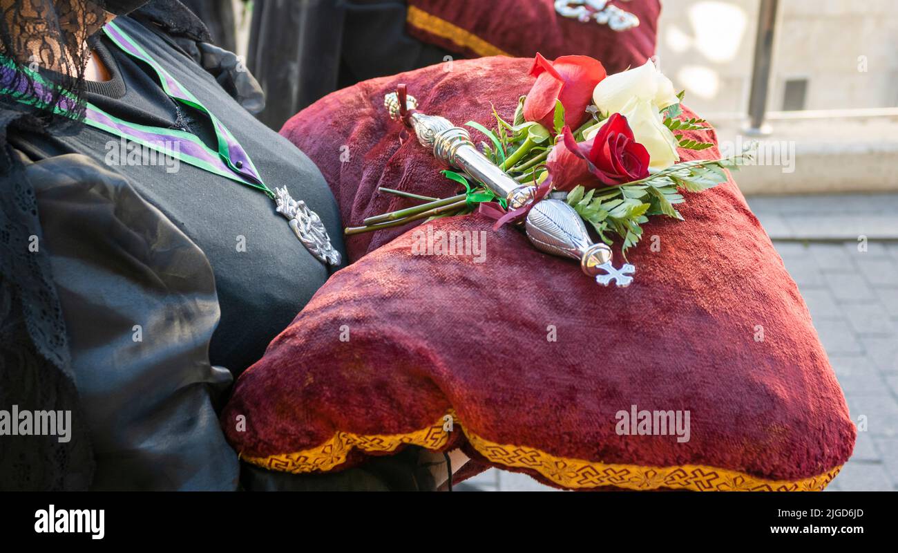 Une femme portant une offrande florale et un personnel d'argent pendant la semaine Sainte à Valladolid, Espagne Banque D'Images