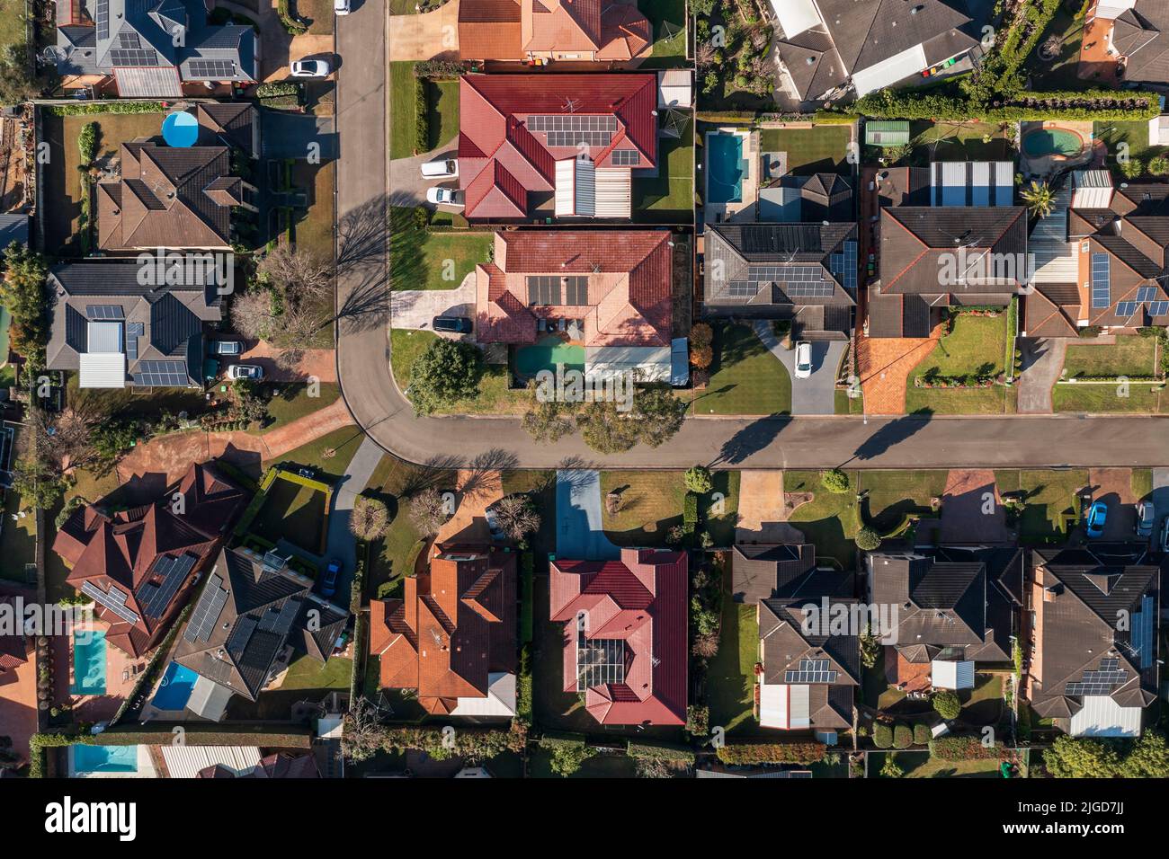 Vue aérienne de haut en bas tôt un matin d'hiver au-dessus d'un coin de rue de quartier dans la banlieue de Sydney, Australie. Banque D'Images