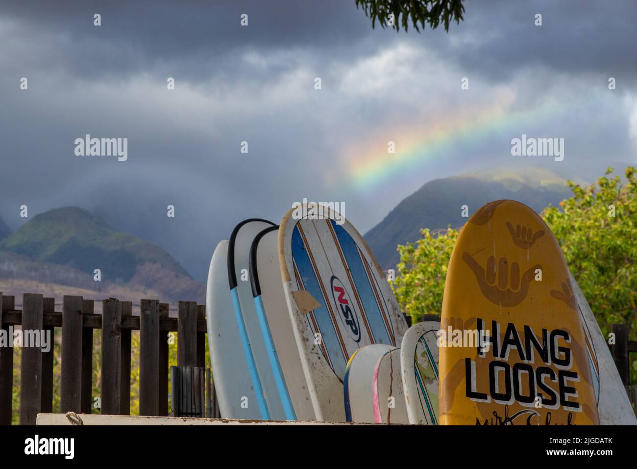 Les montagnes de l'ouest de Maui sont ornées d'un arc-en-ciel qui sert de toile de fond au style de vie classique du surf Hang Loose. Banque D'Images