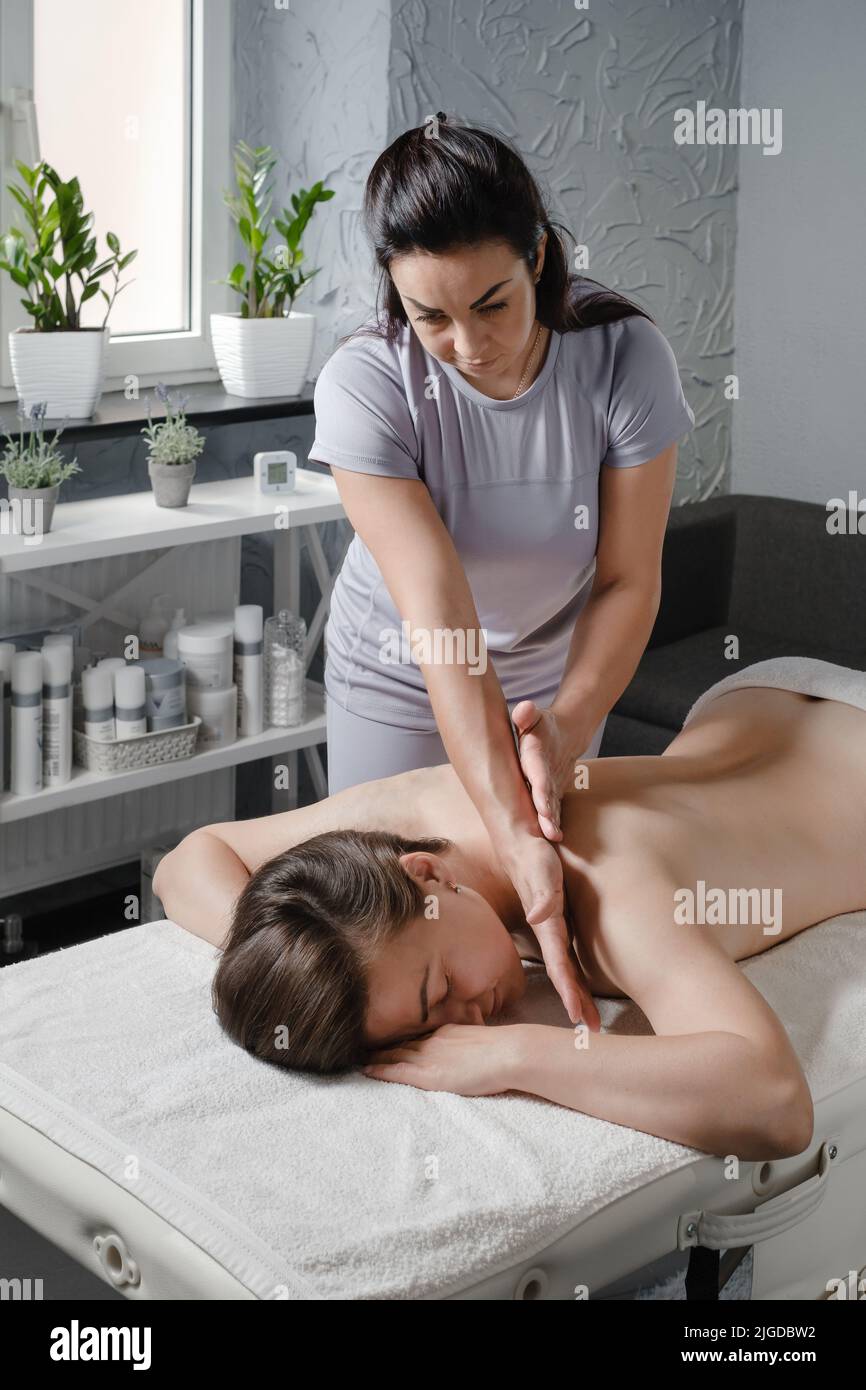 Femme caucasienne ayant un traitement de massage en clinique de thérapie. Massage de dos d'huile, concept de spa et de soins de santé. Soulagement de la douleur. Banque D'Images