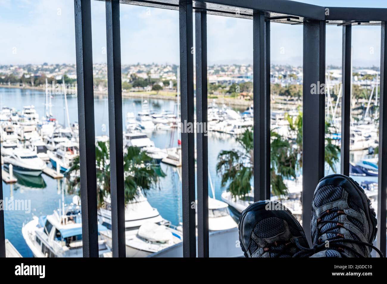 Chaussures reposant sur une table avec balcon vue sur la baie de San Diego en Californie avec bateaux à quai Banque D'Images