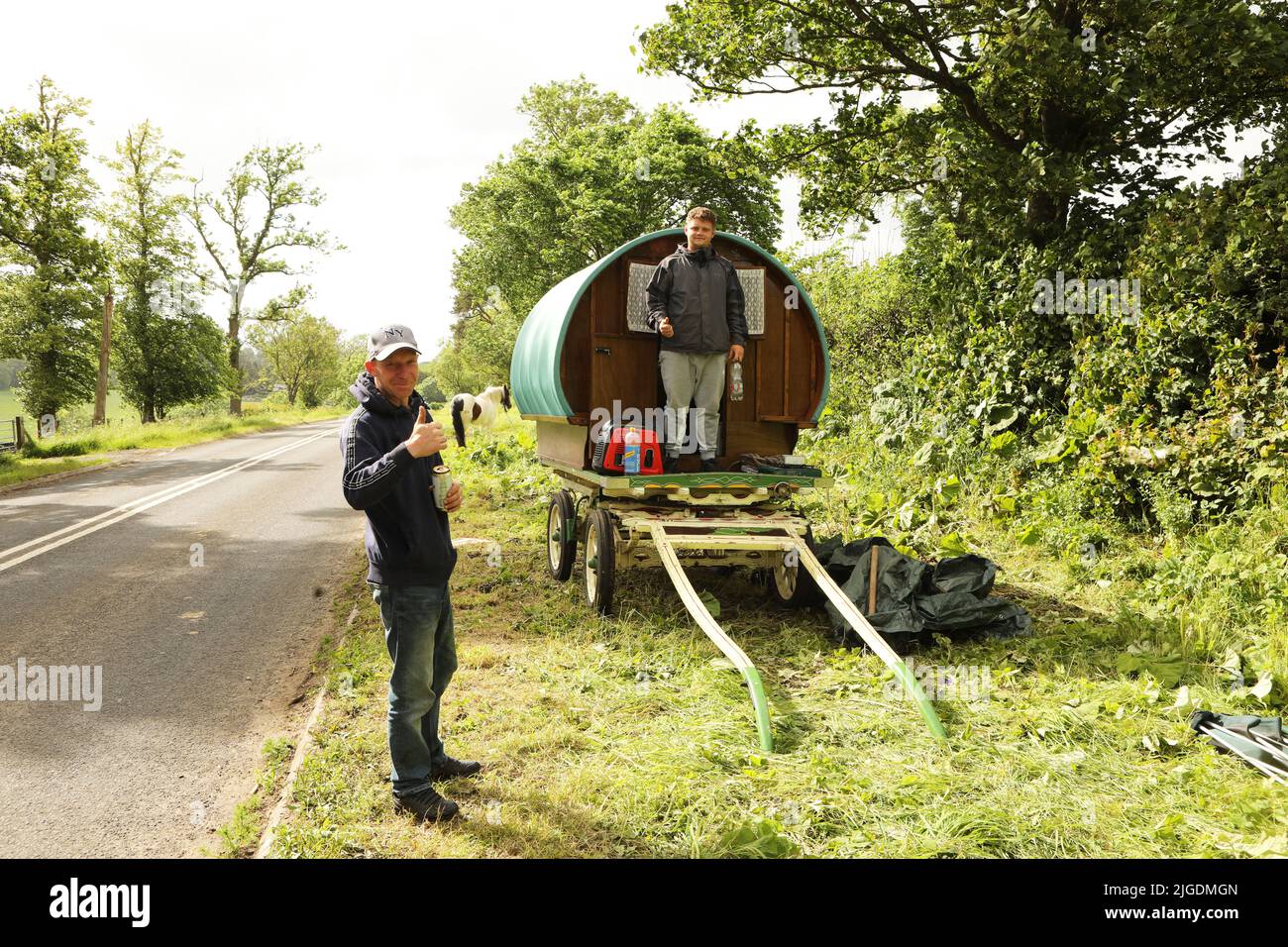 Deux jeunes hommes avec des caravanes tziganes campent sur le bord près de la foire du cheval Appleby, Appleby à Westmorland, Cumbria Banque D'Images