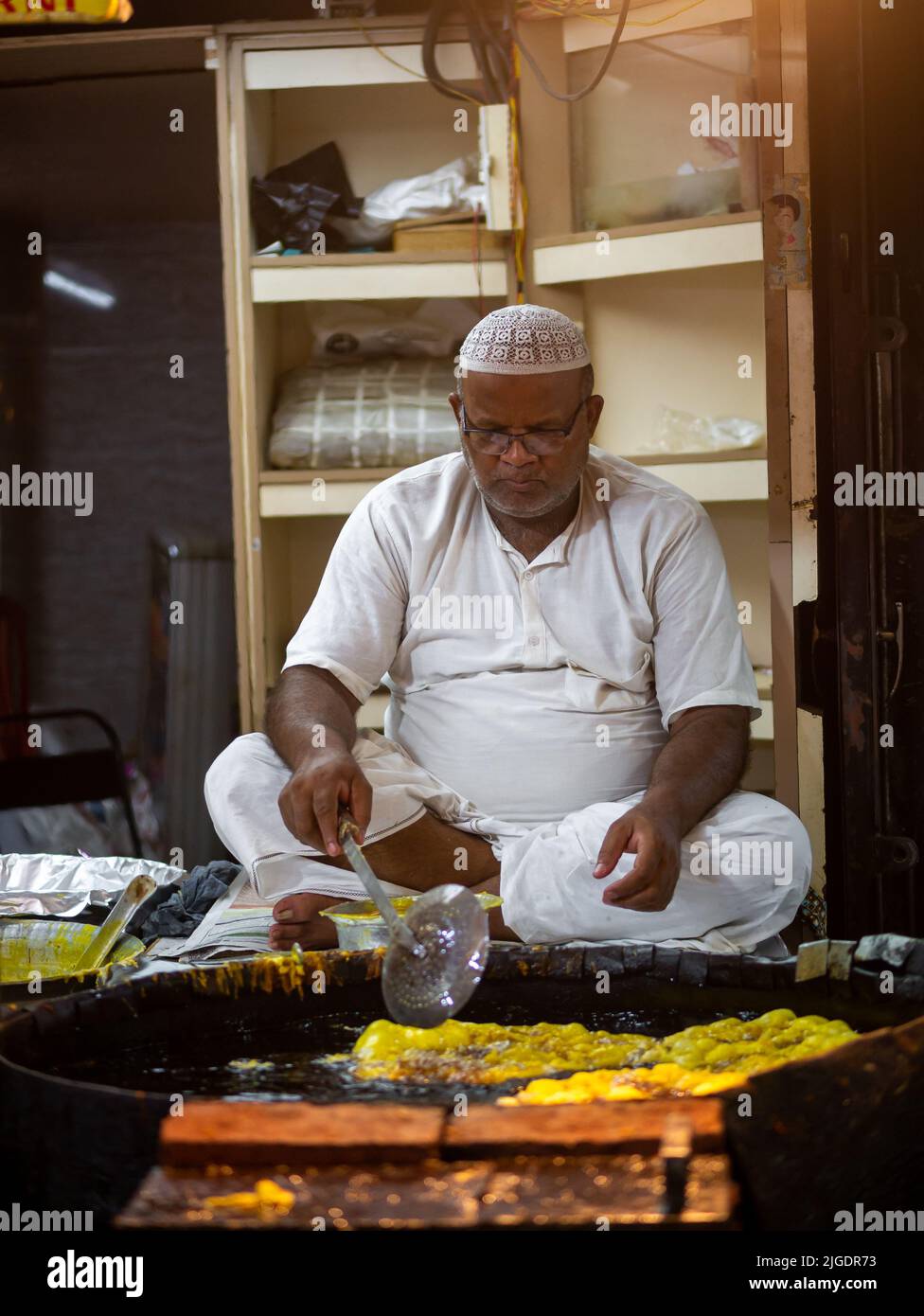 Bombay, Inde - 1 mai 2022 : cuisine masculine musulmane vendant des aliments halal et des collations crêpes frites Malpuas de la stalle de bord de route au marché de nuit en h. Banque D'Images