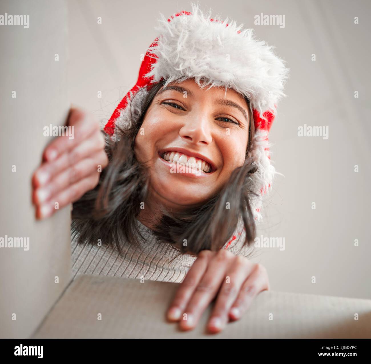 Vous êtes le meilleur cadeau qu'on puisse trouver. Une jeune femme ouvre un cadeau de Noël à la maison. Banque D'Images