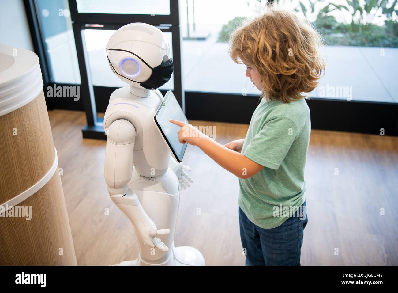 curieux enfant interagir avec robot intelligence artificielle, communication Banque D'Images