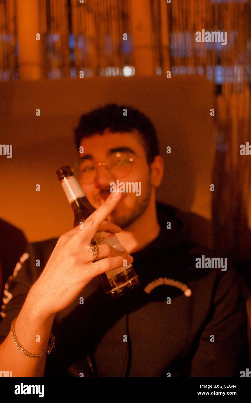 Un homme tenant une bouteille de bière a soulevé son doigt du milieu Banque D'Images