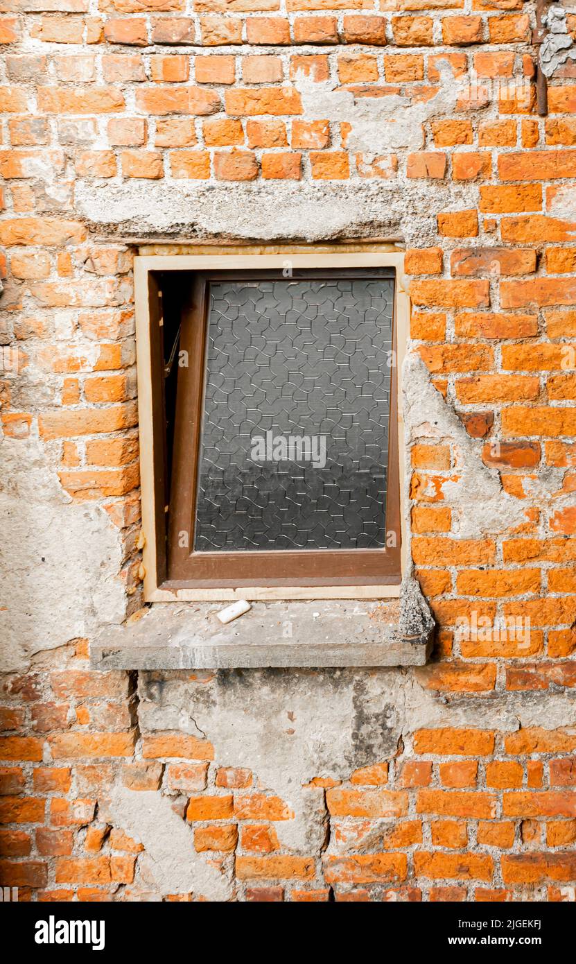 Fenêtre sale dans le mur de brique intérieur d'un bâtiment avec l'apparence désordonnée. Concept - couverture de l'album Banque D'Images
