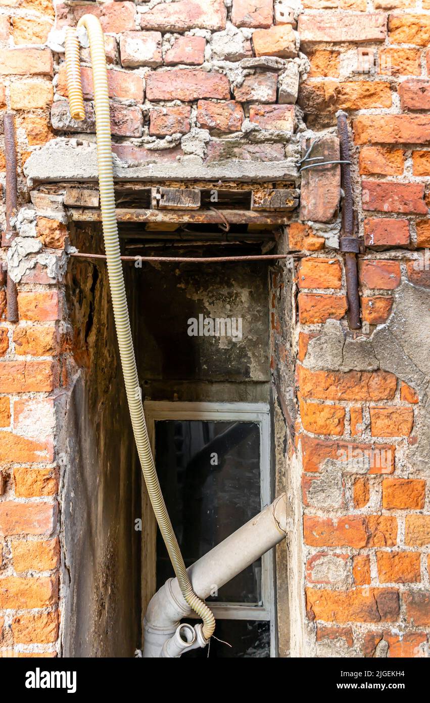 Fenêtre sale dans le mur de brique intérieur d'un bâtiment avec vue bloquée et aspect désordonné. Concept - couverture de l'album Banque D'Images
