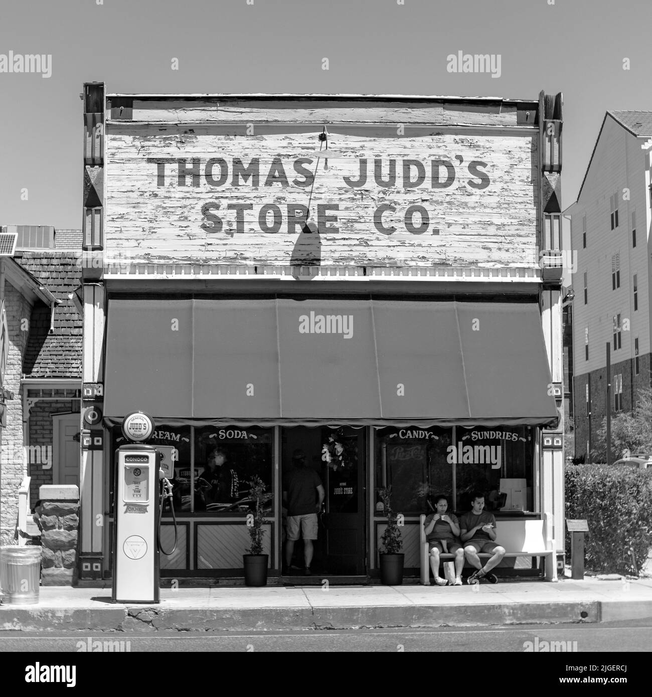 Une photo en noir et blanc de l'ancien magasin en face du centre-ville de St. George Utah « Thomas Judd's Store CO » et de l'ancienne pompe à gaz. Banque D'Images