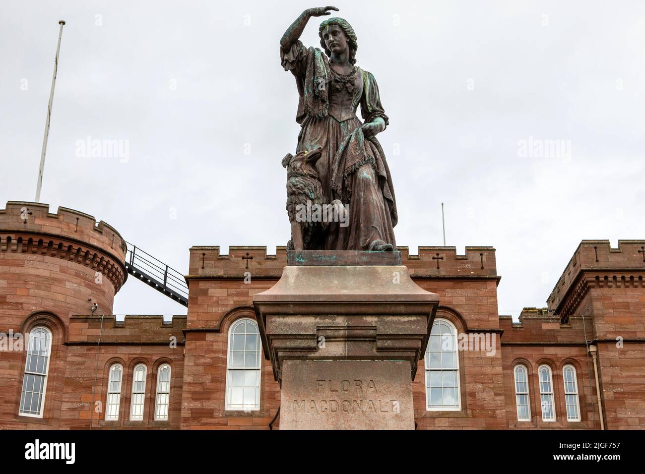 Statue de Flora MacDonald qui a aidé Charles Edward Stuart à échapper aux troupes gouvernementales après la bataille de Culloden en 1746, avec le château d'Inverness dans le Banque D'Images
