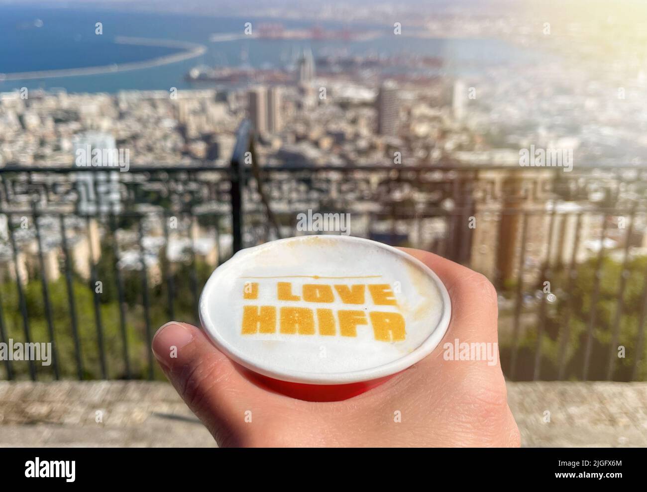 La légende J'AIME HAÏFA dans une tasse de café et une vue sur la ville de Haïfa en arrière-plan. Banque D'Images