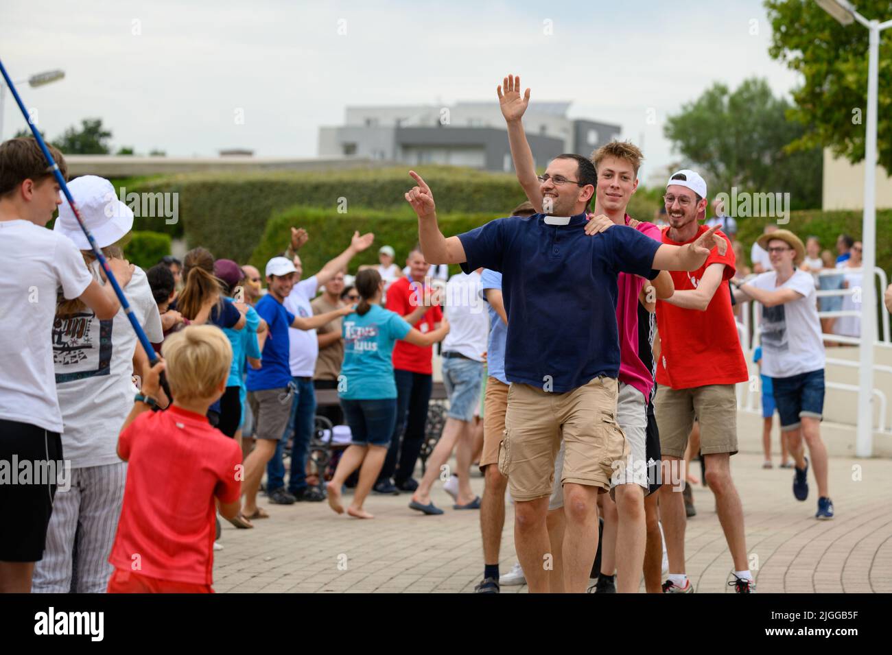 Un prêtre dirigeant des jeunes dans une danse aux chants chrétiens au Mladifest 2021, le festival de la jeunesse, à Medjugorje. Banque D'Images