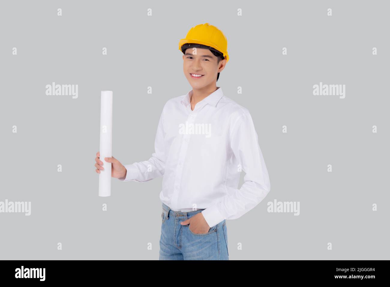 Portrait le jeune asiatique est ingénieur portant un casque debout et tenant le plan avec confiance isolé sur fond blanc, le beau mâle est archi Banque D'Images