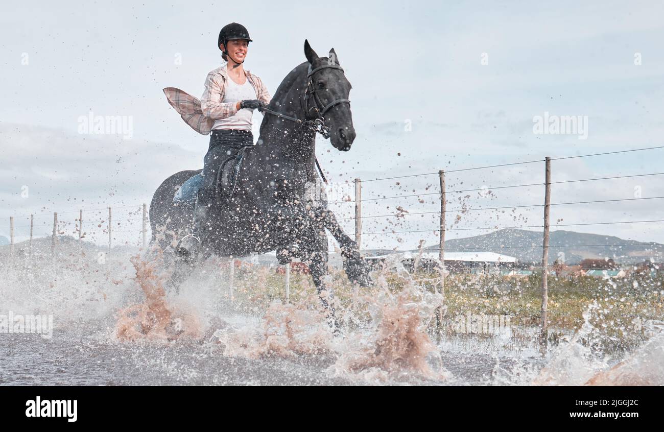 Giddyup. Prise de vue en longueur d'une jeune femme attirante à cheval en plein air sur un ranch. Banque D'Images