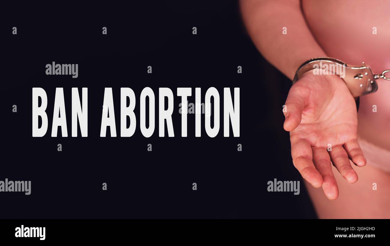 Inscription interdisant l'avortement et la femme enceinte sur fond noir menotté, gros plan. Concept de problèmes avec le manque de liberté pendant la grossesse Banque D'Images