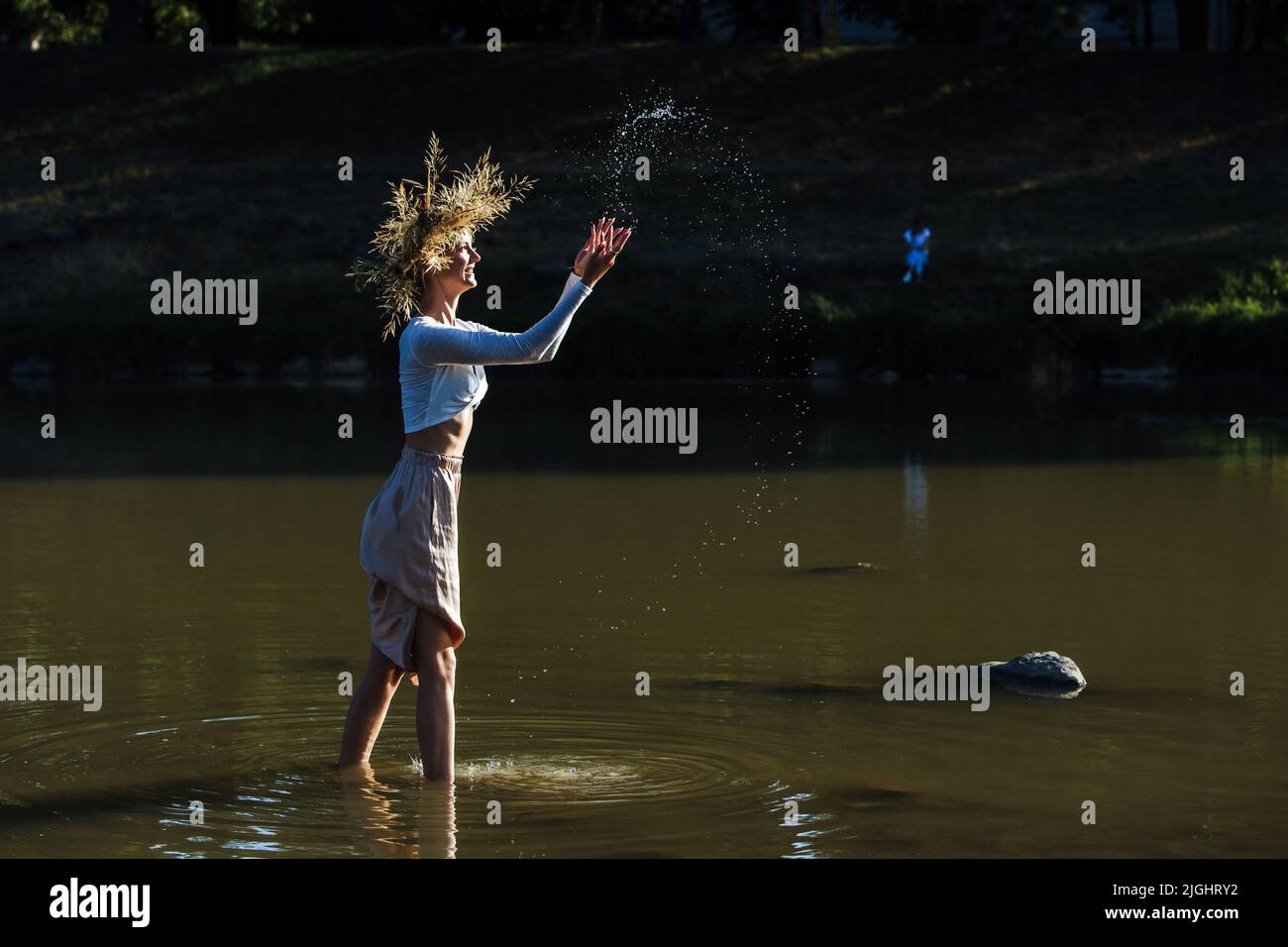 UZHHOROD, UKRAINE - le 8 JUILLET 2022 - Une femme dans une couronne tient à la cheville dans l'eau pendant la célébration de la nuit Kupala organisée par le mouvement pour le TH Banque D'Images