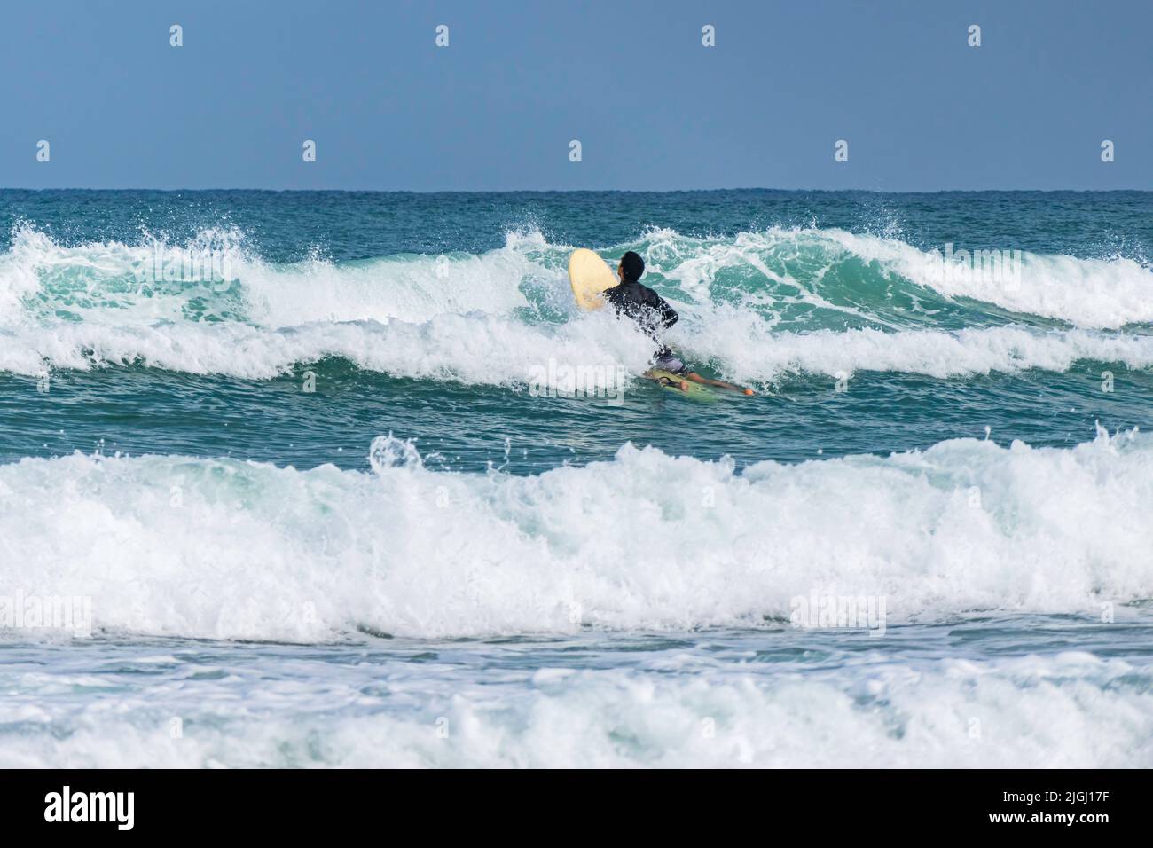 Surfeurs dans l'eau sur les vagues de la mer Méditerranée. Banque D'Images