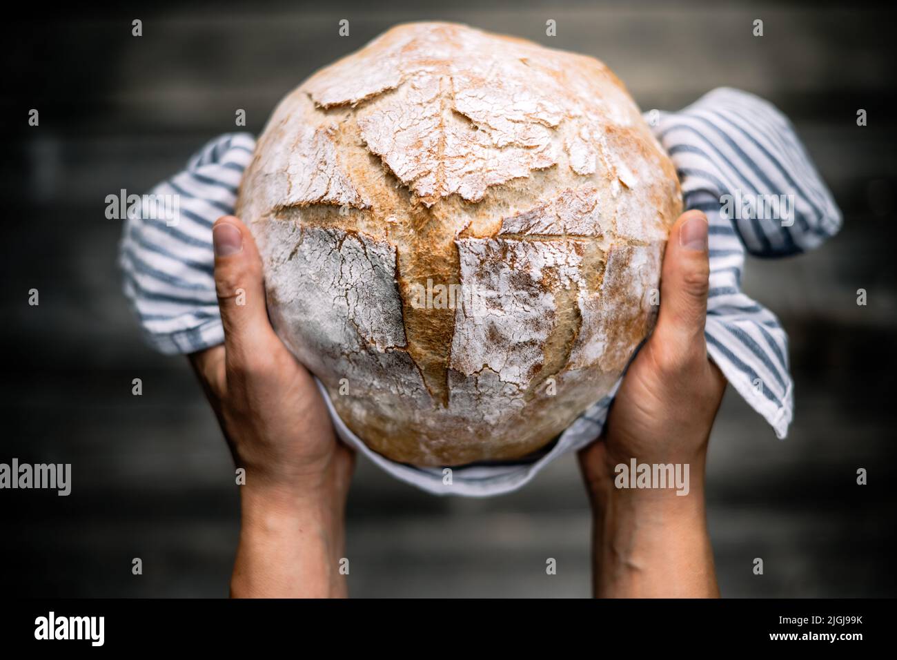 Pain traditionnel levain levain levain aux mains boulangeries sur une table rustique en bois. Photographie d'aliments sains Banque D'Images