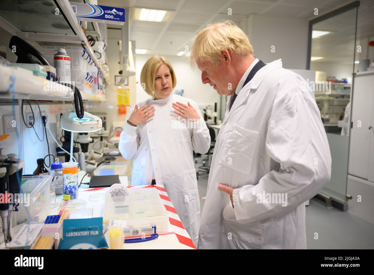 Le Premier ministre Boris Johnson présente des échantillons par Lucy Collinson, chef de la microscopie électronique, dans un laboratoire lors d'une visite au navire amiral national de la recherche biomédicale, le Francis Crick Institute, dans le centre de Londres, Pour souligner un financement récemment annoncé de £1 milliards de dollars pour l'Institut par le Conseil de recherches médicales (MRC), cancer Research UK (CRUK) et le Wellcome Trust. Date de la photo: Lundi 11 juillet 2022. Banque D'Images