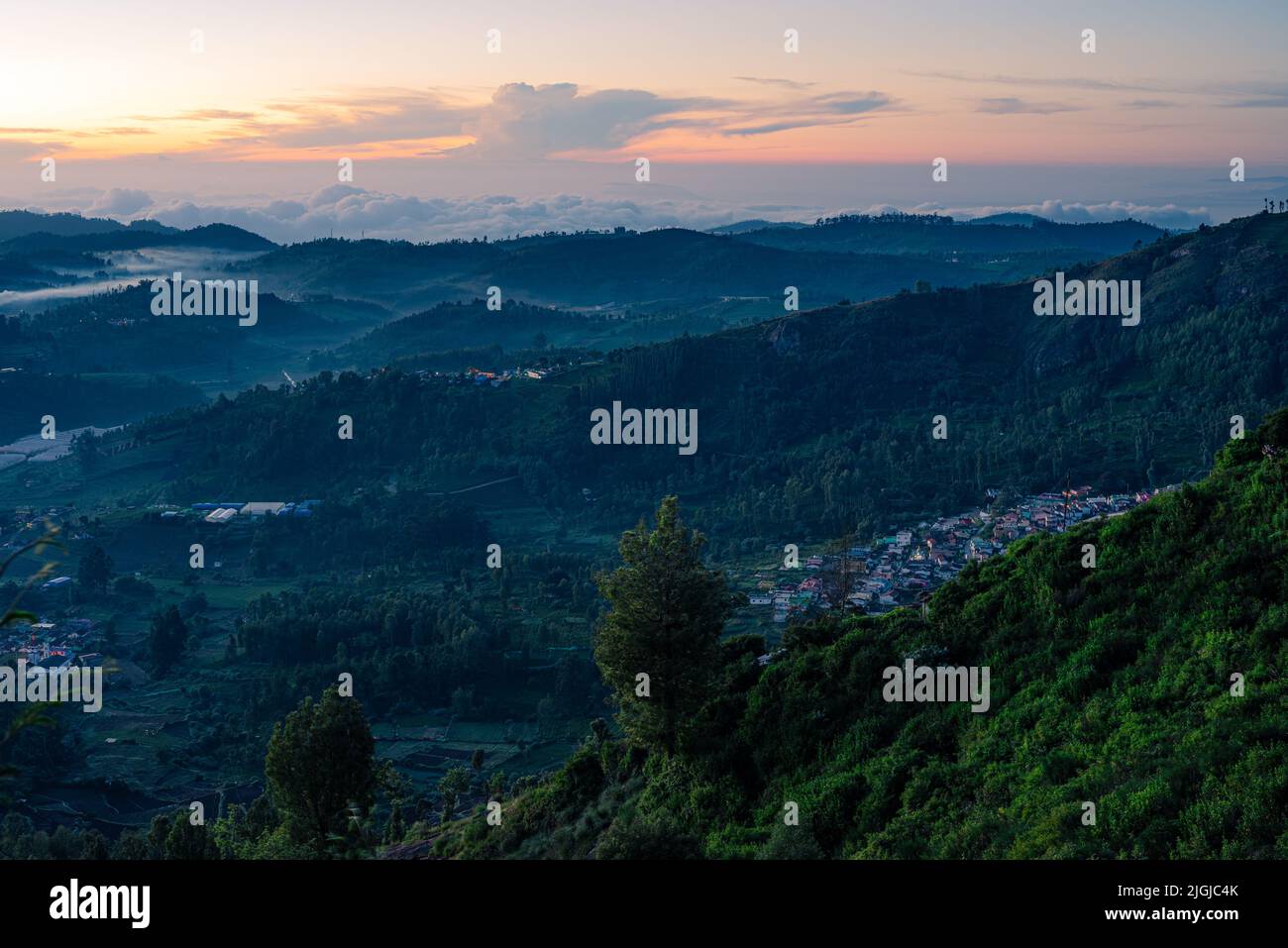 Lever du soleil le matin vue sur les collines d'Ooty avec paysage teinté bleu et ciel orange Banque D'Images