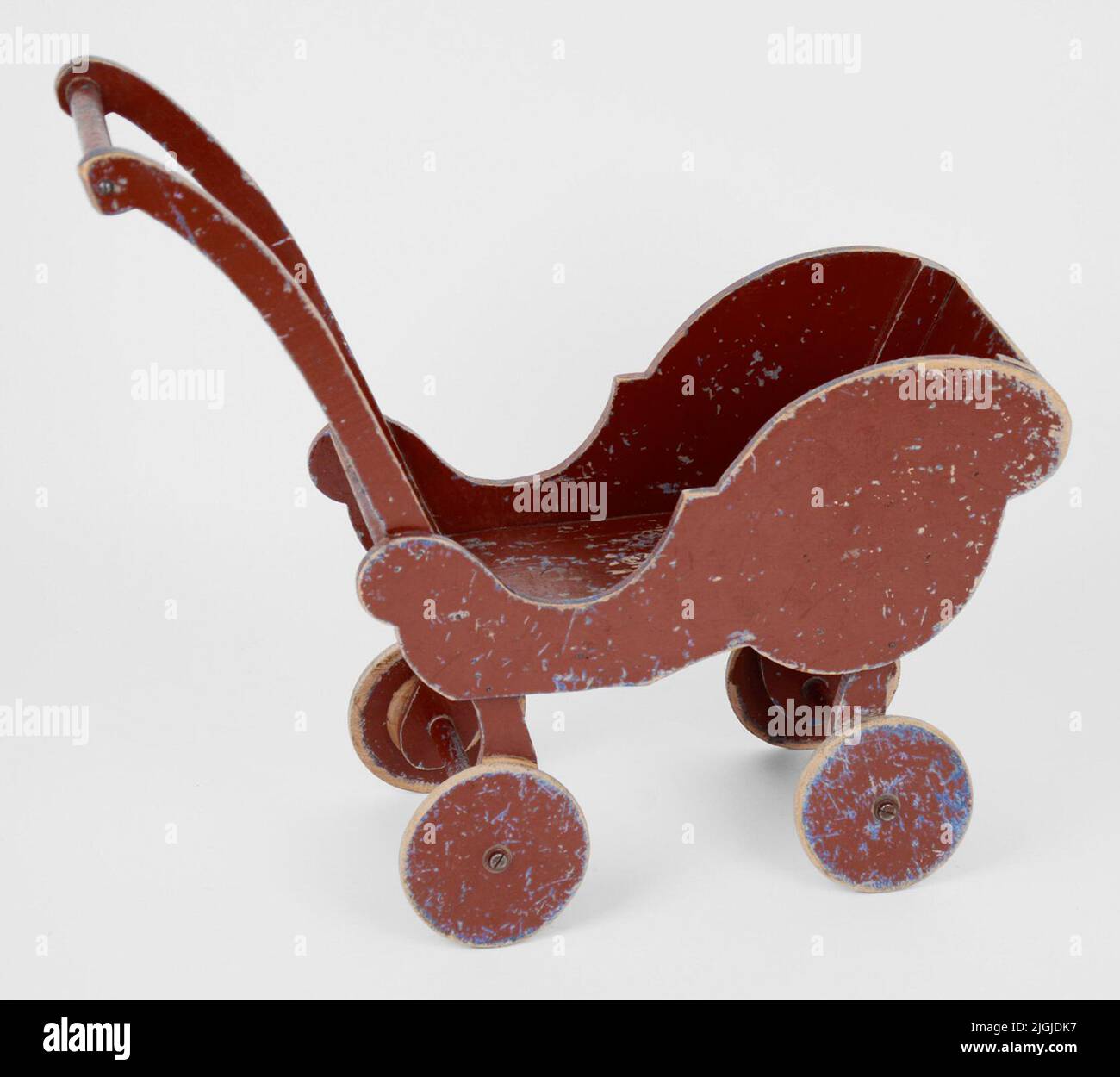 Chariot en bois Dockvagn. Figure - côtés sciés. Essieux de roue et poignées de tige ronde. Aussi les roues de bois. Peint en rouge avec des pistes claires de la couleur bleue précédente. Usé. Fabriqué par le père de l'ouvrier de chantier naval Nils Olsson, Björkholmen, Karlskrona (1913-1998). Nils a fait une armoire de poupée pour Gerd et était également bon au travail de feuilles. GERD est né en 1937. Don 2013-02-27 par Gerd Wendt, Karlskrona Banque D'Images